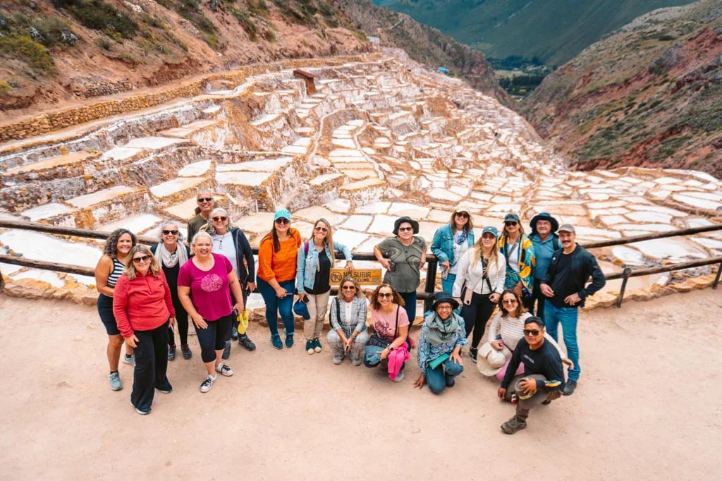 Group of tourists taking a picture at Maras salt ponds in Peru